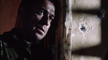 Movie still from “Dog Soldiers” (2002), directed by Neil Marshall – A person looking at the camera; Close Up shot, Low angle