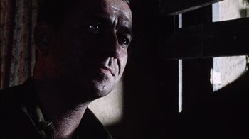 Movie still from “Dog Soldiers” (2002), directed by Neil Marshall – A person looking at the camera; Close Up shot, Low angle