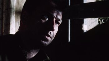 Movie still from “Dog Soldiers” (2002), directed by Neil Marshall – A person in a dark room; Close Up shot, Low angle