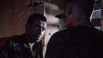 Movie still from “Dog Soldiers” (2002), directed by Neil Marshall – A man in a military uniform looking at another man in a military uniform; Close Up shot, Over the shoulder angle
