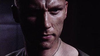 Movie still from “Dog Soldiers” (2002), directed by Neil Marshall – A man's face in the dark; Close Up shot, Low angle