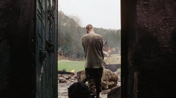 Movie still from “Dog Soldiers” (2002), directed by Neil Marshall – A man standing in front of an open door; Wide shot, Over the shoulder angle
