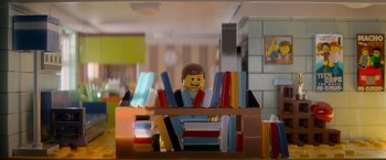 Movie still from “The Lego Movie” (2014), directed by Phil Lord – A lego man sitting in front of some books; Medium shot, Over the shoulder angle