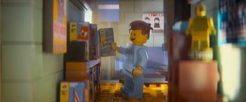 Movie still from “The Lego Movie” (2014), directed by Phil Lord – A lego man is standing in front of a book case; Medium shot, Over the shoulder angle