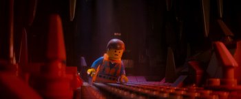Movie still from “The Lego Movie” (2014), directed by Phil Lord – A lego man is sitting on a keyboard; Medium shot, Over the shoulder angle