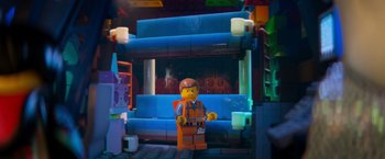 Movie still from “The Lego Movie” (2014), directed by Phil Lord – A lego man standing in front of a blue couch; Wide shot, Over the shoulder angle