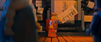 Movie still from “The Lego Movie” (2014), directed by Phil Lord – A lego man that is holding a piece of paper; Medium shot, Over the shoulder angle