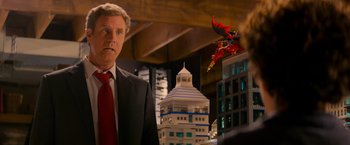 Movie still from “The Lego Movie” (2014), directed by Phil Lord – A man wearing a suit and red tie standing in front of a building; Medium shot, Over the shoulder angle
