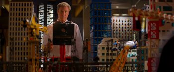 Movie still from “The Lego Movie” (2014), directed by Phil Lord – A man standing in front of a model of a building; Medium shot, Over the shoulder angle