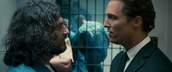 Movie still from “The Lincoln Lawyer” (2011), directed by Brad Furman – Two men in suits facing each other in front of a cage; Close Up shot, Over the shoulder angle