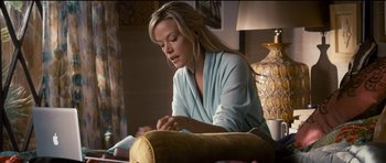 Movie still from “The Lincoln Lawyer” (2011), directed by Brad Furman – A woman sitting at a table sewing a pillow; Medium shot, High angle