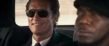 Movie still from “The Lincoln Lawyer” (2011), directed by Brad Furman – A person wearing a suit and sunglasses; Close Up shot, Over the shoulder angle