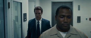 Movie still from “The Lincoln Lawyer” (2011), directed by Brad Furman – A man in a suit and tie standing next to another man in a suit and tie; Close Up shot, Over the shoulder angle
