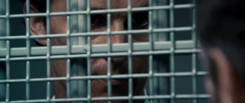 Movie still from “The Lincoln Lawyer” (2011), directed by Brad Furman – A person behind a metal fence; Extreme Close Up shot, Over the shoulder angle