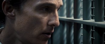 Movie still from “The Lincoln Lawyer” (2011), directed by Brad Furman – A man's face in front of a jail cell; Close Up shot, Over the shoulder angle