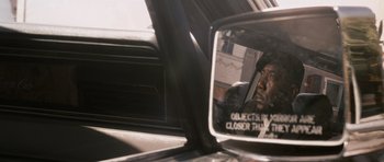 Movie still from “The Lincoln Lawyer” (2011), directed by Brad Furman – A rear view mirror of a car with a reflection of a man in the mirror; Close Up shot, Over the shoulder angle