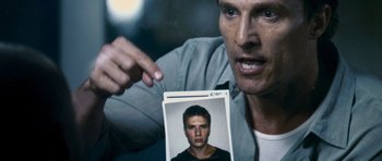 Movie still from “The Lincoln Lawyer” (2011), directed by Brad Furman – A man holding up a picture of himself; Close Up shot, High angle