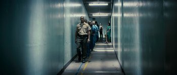 Movie still from “The Lincoln Lawyer” (2011), directed by Brad Furman – A group of men in blue uniforms walking down a hallway; Wide shot, Low angle