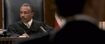 Movie still from “The Lincoln Lawyer” (2011), directed by Brad Furman – A man wearing a black robe is speaking at a podium; Close Up shot, Low angle