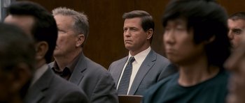 Movie still from “The Lincoln Lawyer” (2011), directed by Brad Furman – A man wearing a suit and tie sitting in a courtroom; Medium shot, Over the shoulder angle