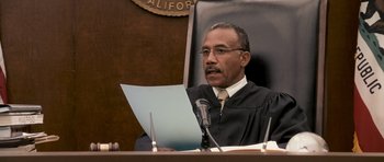Movie still from “The Lincoln Lawyer” (2011), directed by Brad Furman – A man in a courtroom holding papers and a microphone; Close Up shot, Low angle