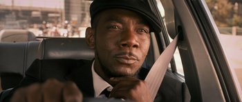 Movie still from “The Lincoln Lawyer” (2011), directed by Brad Furman – A man in a car holding a large knife; Close Up shot, High angle