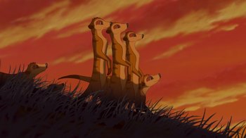 Movie still from “The Lion King” (1994), directed by Rob Minkoff – A group of meerkats standing on top of a grass covered hill; Wide shot, Low angle