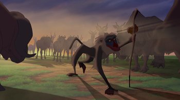 Movie still from “The Lion King” (1994), directed by Rob Minkoff – An animated scene of a monkey with a bow and arrow; Wide shot, Low angle