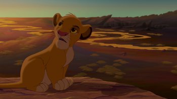 Movie still from “The Lion King” (1994), directed by Rob Minkoff – A lion cub sitting on top of a hill; Wide shot, Low angle