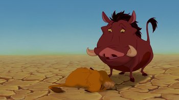 Movie still from “The Lion King” (1994), directed by Rob Minkoff – An animal laying on the ground next to an ox; Wide shot, Overhead angle
