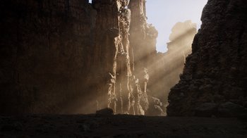 Movie still from “The Lion King” (2019), directed by Jon Favreau – The sun is shining through the clouds on a rock wall; Extreme Wide shot, Low angle