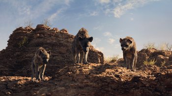 Movie still from “The Lion King” (2019), directed by Jon Favreau – Three hyenas standing on top of a rocky hill; Wide shot, Low angle