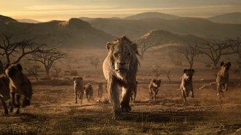 Movie still from “The Lion King” (2019), directed by Jon Favreau – A group of lions walking across a dry grass field; Wide shot, Low angle