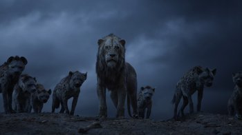 Movie still from “The Lion King” (2019), directed by Jon Favreau – A group of hyenas standing next to an adult lion; Wide shot, Low angle