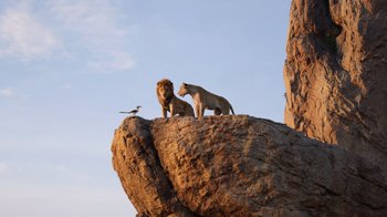 Movie still from “The Lion King” (2019), directed by Jon Favreau – A couple of lions standing on top of a large rock; Extreme Wide shot, Low angle