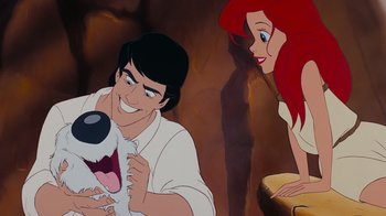 Movie still from “The Little Mermaid” (1989), directed by John Musker – A man and a woman are smiling for the camera; Medium shot, Over the shoulder angle