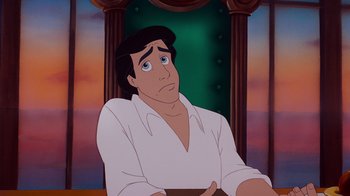 Movie still from “The Little Mermaid” (1989), directed by John Musker – A man sitting in front of a painting of a castle; Medium shot, High angle