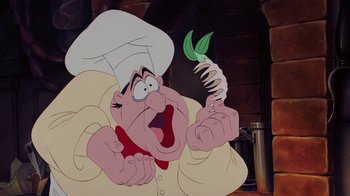 Movie still from “The Little Mermaid” (1989), directed by John Musker – An animated character is holding a plant in his hand; Close Up shot, Over the shoulder angle
