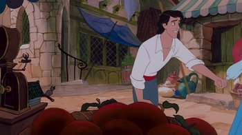Movie still from “The Little Mermaid” (1989), directed by John Musker – A cartoon character with a bunch of apples in front of him; Medium shot, Overhead angle