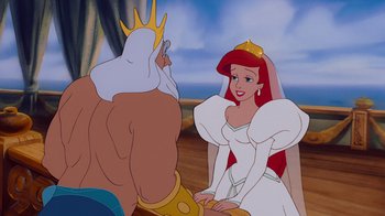 Movie still from “The Little Mermaid” (1989), directed by John Musker – A couple of people that are sitting down in front of each other; Medium shot, Over the shoulder angle