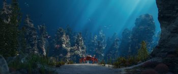 Movie still from “The Little Mermaid” (2023), directed by Rob Marshall – A red crab is sitting on the bottom of the ocean; Extreme Wide shot, High angle