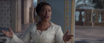 Movie still from “The Little Mermaid” (2023), directed by Rob Marshall – An older african american woman in a white dress talking; Close Up shot, Over the shoulder angle