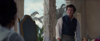 Movie still from “The Little Mermaid” (2023), directed by Rob Marshall – A man wearing a vest standing in front of a mirror; Medium shot, Over the shoulder angle