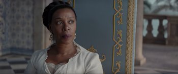 Movie still from “The Little Mermaid” (2023), directed by Rob Marshall – An older woman in a white dress looking at the camera; Close Up shot, Over the shoulder angle