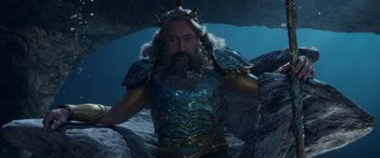 Movie still from “The Little Mermaid” (2023), directed by Rob Marshall – A man with a long beard wearing a crown; Medium shot, High angle