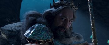 Movie still from “The Little Mermaid” (2023), directed by Rob Marshall – A man with long hair and a beard wearing a crown and holding a sword; Close Up shot, Low angle