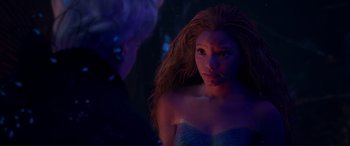 Movie still from “The Little Mermaid” (2023), directed by Rob Marshall – A woman with long hair is standing in a dark room; Close Up shot, Over the shoulder angle