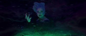 Movie still from “The Little Mermaid” (2023), directed by Rob Marshall – A woman in a black dress and a black and blue background; Medium shot, Overhead angle