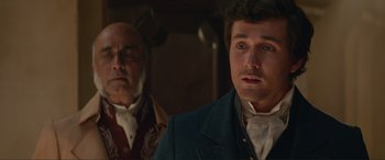 Movie still from “The Little Mermaid” (2023), directed by Rob Marshall – A man in a suit and a man with a beard; Close Up shot, Over the shoulder angle