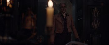 Movie still from “The Little Mermaid” (2023), directed by Rob Marshall – A man standing in front of a candle in a room; Medium shot, Over the shoulder angle